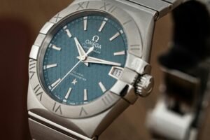 Close-up of a luxury silver wristwatch with a blue dial, showcasing precision and elegance.